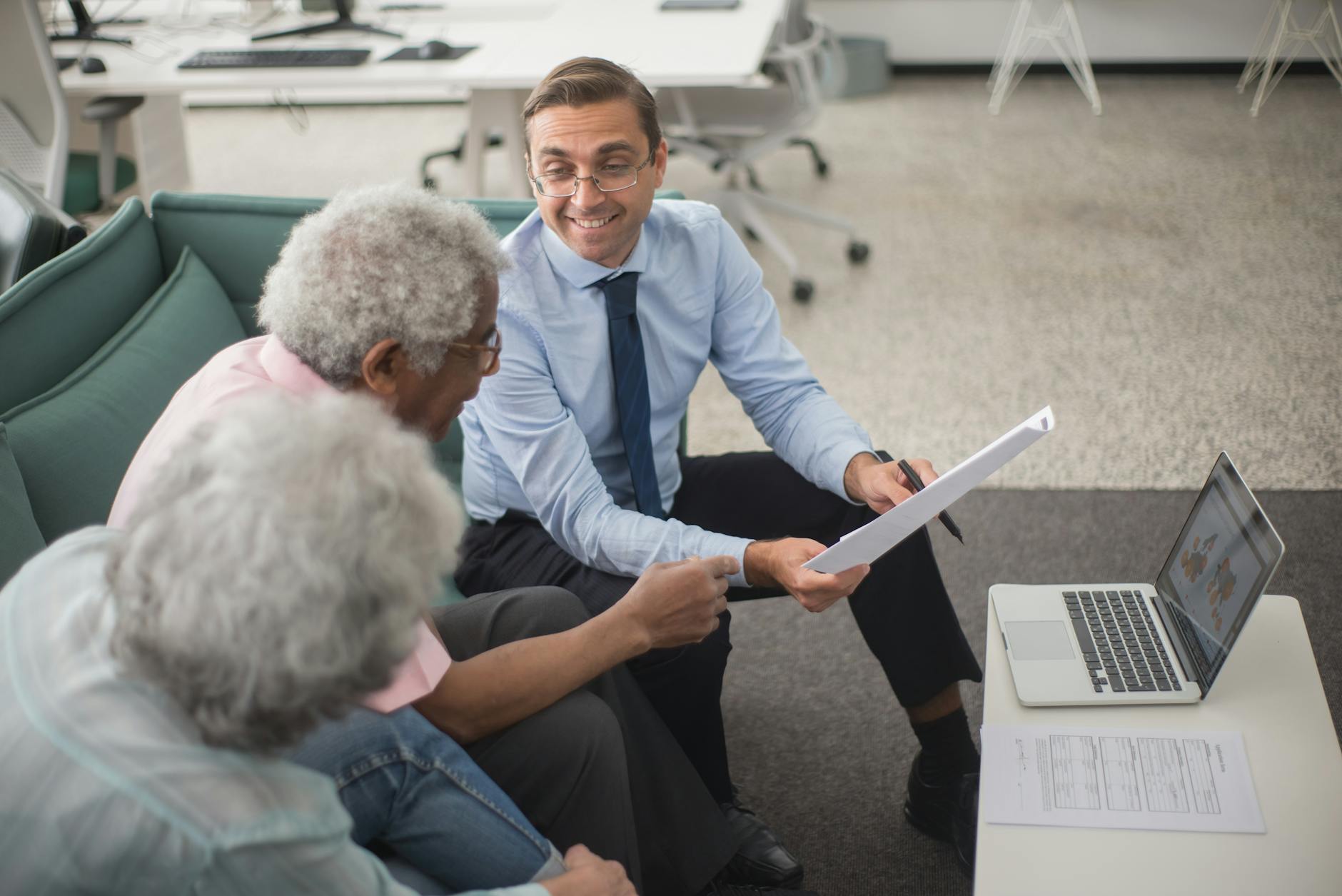 Adviser walking clients through a financial plan in a modern office